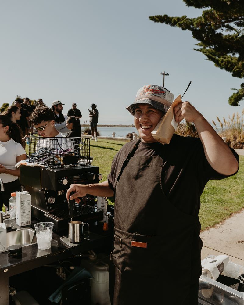 Good Fortune Coffee Club barista raising a drink